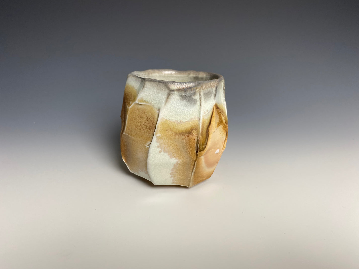 Wood fired faceted yunomi, porcelain clay.