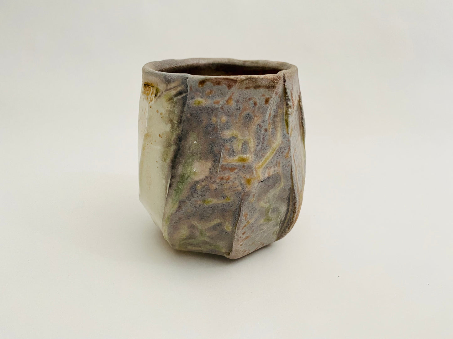 Wood fired porcelain faceted cup.