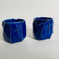 A pair of small faceted blue cups