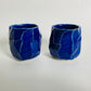 A pair of faceted blue cups