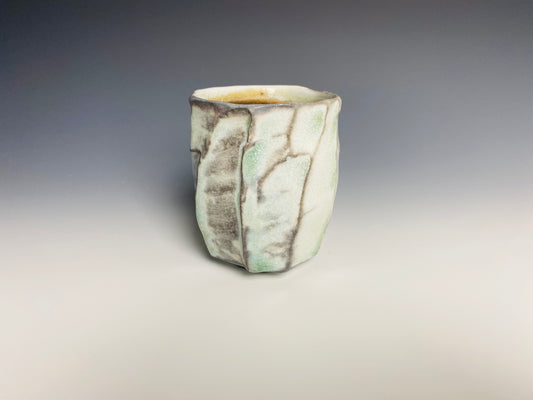 Wood fired faceted yunomi with natural ash glaze and shell marks