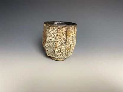 Wood fired faceted yunomi with crackle slip, black clay.