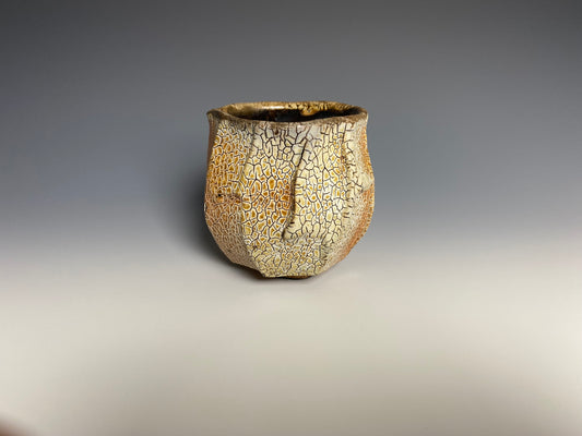 Wood fired faceted yunomi with crackle slip, black clay.