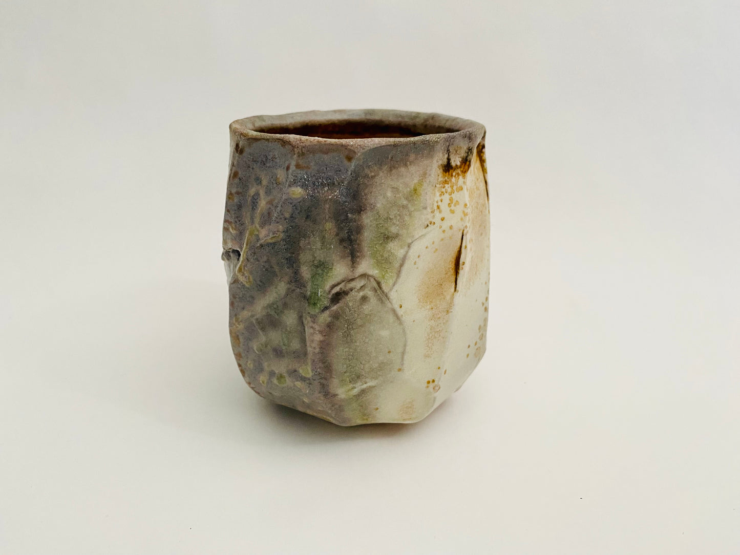 Wood fired porcelain faceted cup.